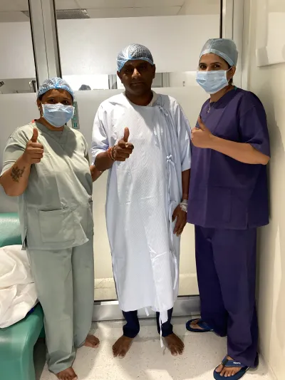 A smiling patient with the surgical team after cataract surgery